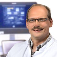 Porträtfoto Stefan Klingebiel Facharzt Neurologie vor Monitor